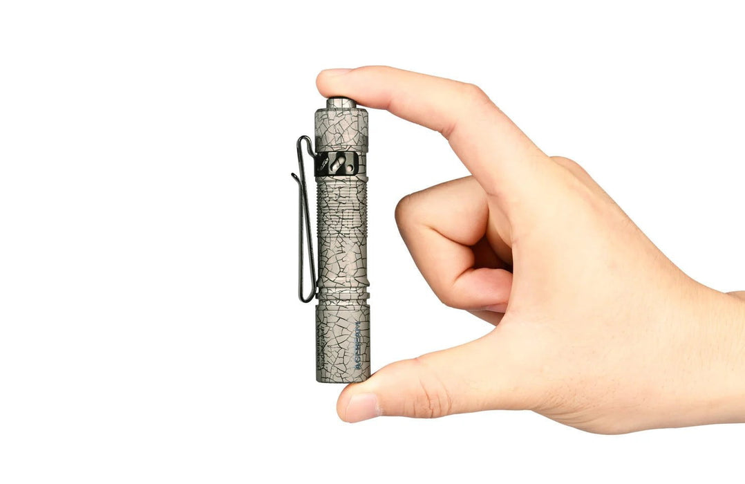 A person's hand holding an Acebeam Pokelit AA Ti 519A, a compact flashlight powered by AA batteries.