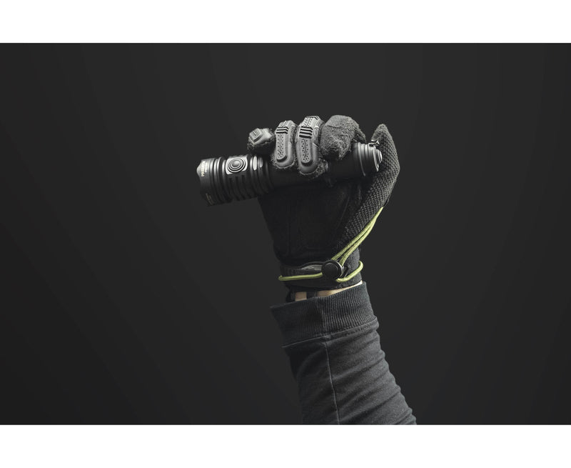 A gloved hand holds the Armytek Predator Pro Max military-grade flashlight upright against a plain dark background.