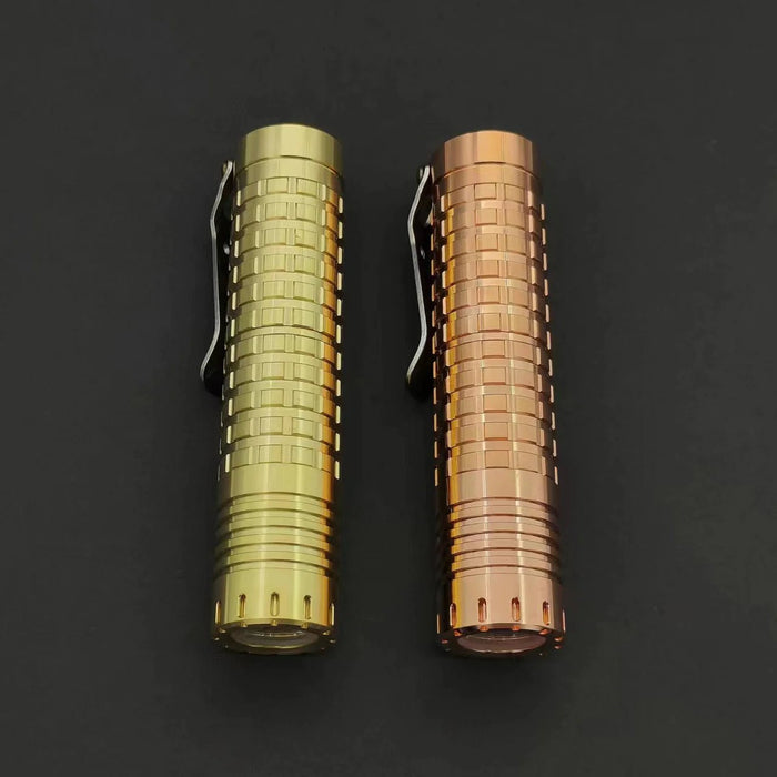 Two ReyLight Dawn - Copper flashlights on a black surface.