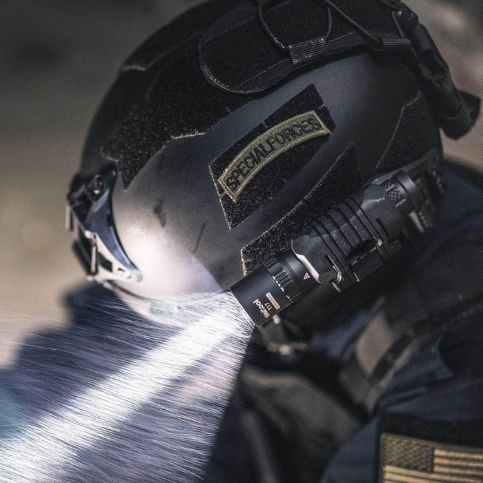 A durable soldier wearing a helmet with a Weltool T17 tactical flashlight.