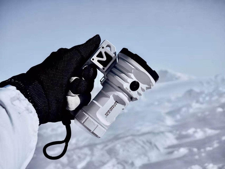 A person holding a Manker MK38 Satellite (Power by 3x 21700 Batteries) on top of a snowy mountain.