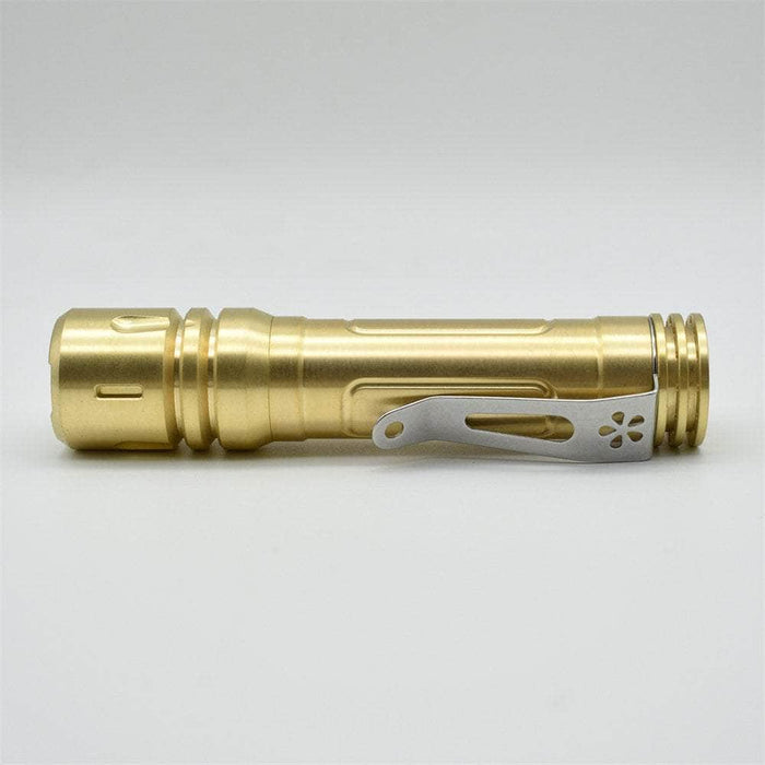 A ReyLight LAN Brass flashlight on a white background.