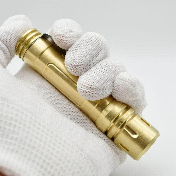 A person holding a ReyLight LAN Brass flashlight in white gloves.