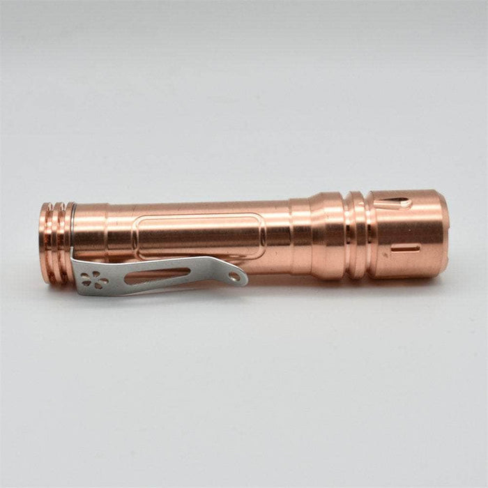 A ReyLight LAN Copper flashlight with a metal handle.