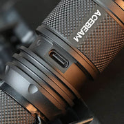 Close-up of the Acebeam P16 2.0 Dual Tail Switch Tactical Flashlight in black, showing its textured grip and USB-C charging port.