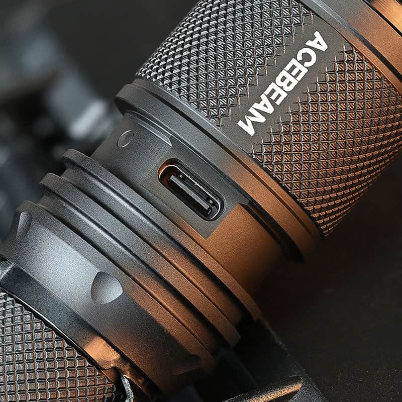 Close-up of the Acebeam P16 2.0 Dual Tail Switch Tactical Flashlight in black, showing its textured grip and USB-C charging port.