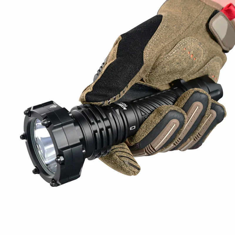 A gloved hand holds the Acebeam P20 Mini, a black tactical flashlight with a ridged body and reinforced bezel, positioned against a white background—showcasing the durability and design of this long distance flashlight.