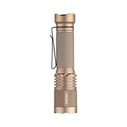 A metallic, tan-colored Acebeam TAC AA 2.0 tactical EDC flashlight featuring a textured grip, side clip, and the “TACAA” label on its lower section is displayed against a white background. This flashlight delivers up to 900 lumens of brightness for reliable performance in any situation.