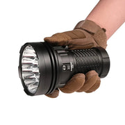 A gloved hand holds the Acebeam X25, a powerful flashlight with multiple LED bulbs and 22,000 lumens output, against a plain white background.