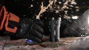 Acebeam X80GT 3 expedition flashlight standing on wet rock in a night field setting