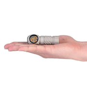 The Acebeam H17 2.0 headlamp, featuring three warm white LED bulbs, fits comfortably on an open palm to highlight its compact size.