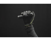 A gloved hand holds the Armytek Dobermann Pro Max tactical flashlight against a dark background.