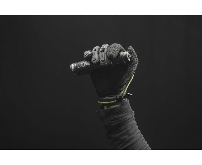 A gloved hand holds the Armytek Dobermann Pro Max tactical flashlight against a dark background.