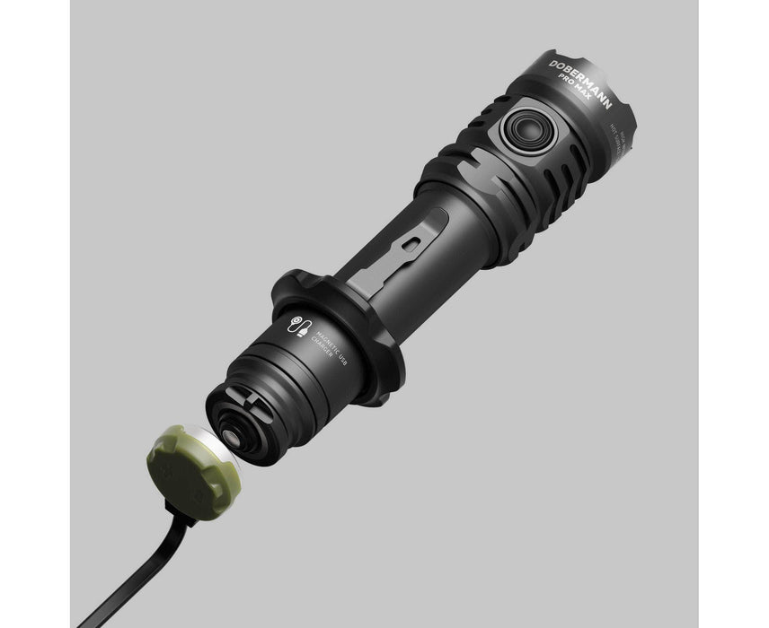 A black Armytek Dobermann Pro Max tactical flashlight with a detachable end cap and cable is shown on a plain grey background.