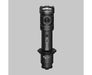 The Armytek Dobermann Pro Max tactical flashlight stands upright on a gray surface, highlighting its side switch and labeled magnetic USB charging port.