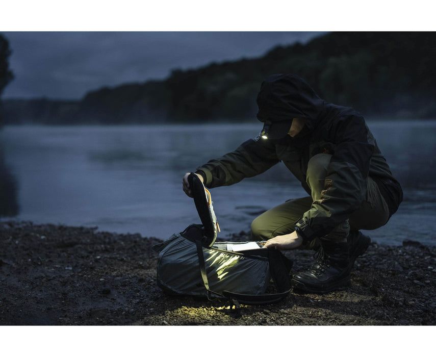 A man using an Armytek Prime C1 Pro Magnet USB at night near a river.