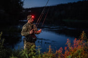 Angler wearing the Elf C2 Max WR headlamp with red light by the water
