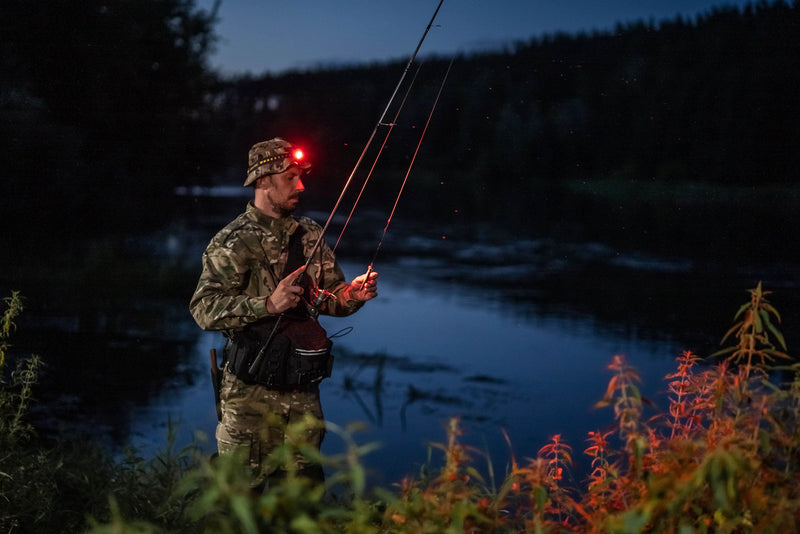 Angler wearing the Elf C2 Max WR headlamp with red light by the water