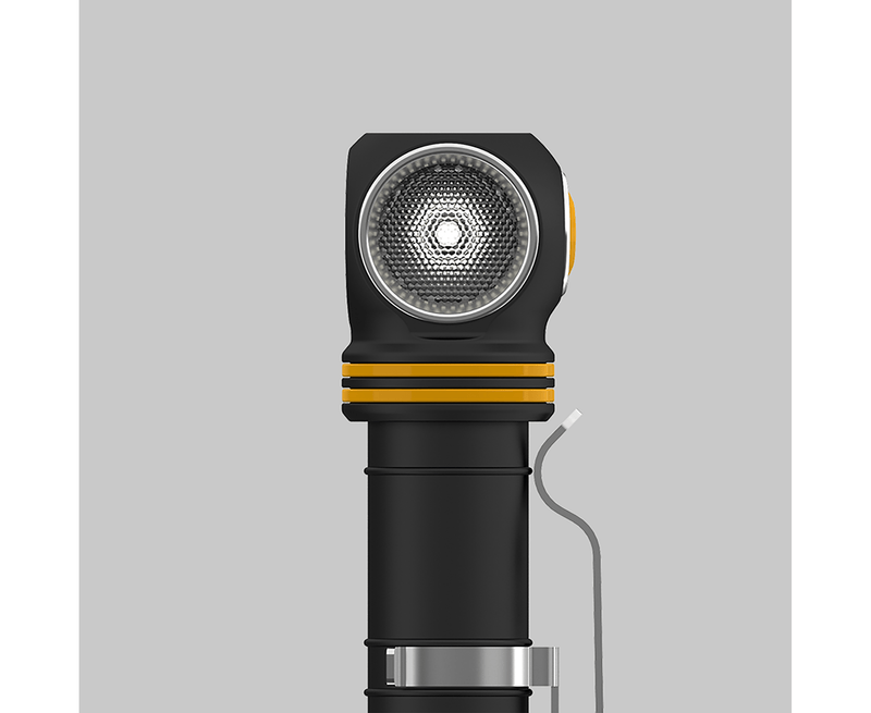 Close-up of an Armytek Elf C2 USB-C Warm flashlight, featuring a black casing with a warm yellow ring and textured lens, positioned upright against a plain gray background and offering convenient USB-C charging.