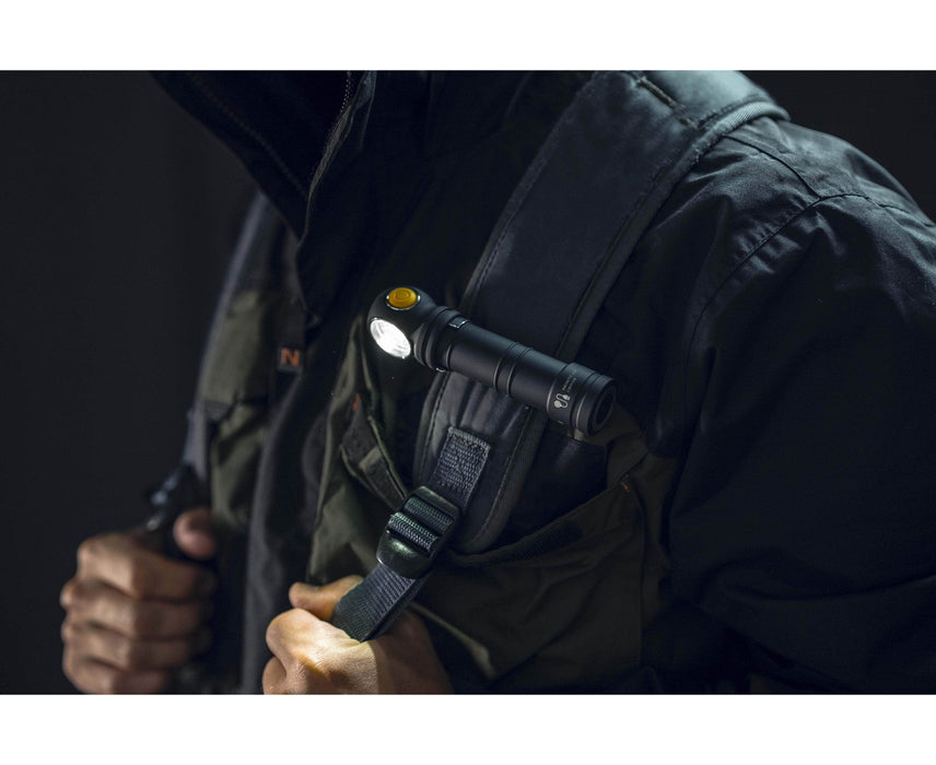 A man is holding a flashlight in his backpack. The flashlight he has is an Armytek Wizard C2 Pro Max LR - Warm, emitting a warm light.