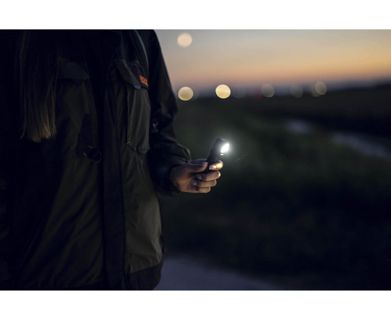 An Armytek Wizard C2 Pro Max LR - Warm woman holding a cell phone at night.