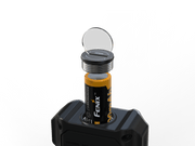 The sleek black Fenix CL27R is equipped by gently placing a battery into the device, with its circular cover flipped open against a matching black background. This 1600 Lumen lantern offers efficient power management for your adventures and is conveniently USB-C rechargeable.