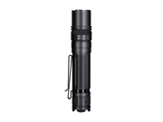 The Fenix PD36R V2 tactical flashlight in black delivers 1700 lumens, comes with a textured grip and a handy pocket clip, stands upright on a simple background, and conveniently charges via USB Type-C.