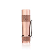 The Lumintop FWAA Copper is a compact, rose gold copper flashlight featuring a textured grip and a metal pocket clip, shown standing upright on a white background—making it an ideal everyday carry flashlight for both style and convenience.