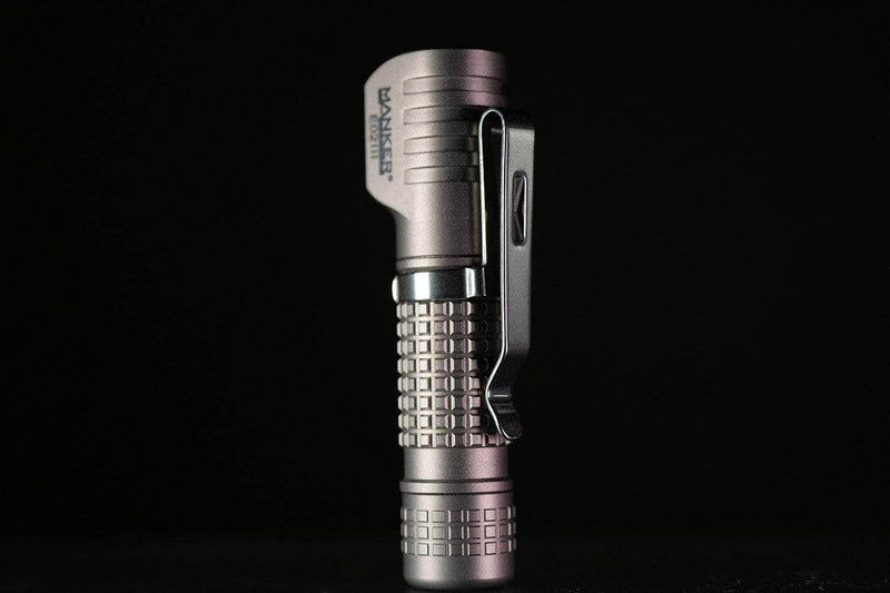 The Manker E02 III - Titanium flashlight features a textured grip and pocket clip, stands upright against a black background, and delivers an impressive 560 lumens for everyday carry.