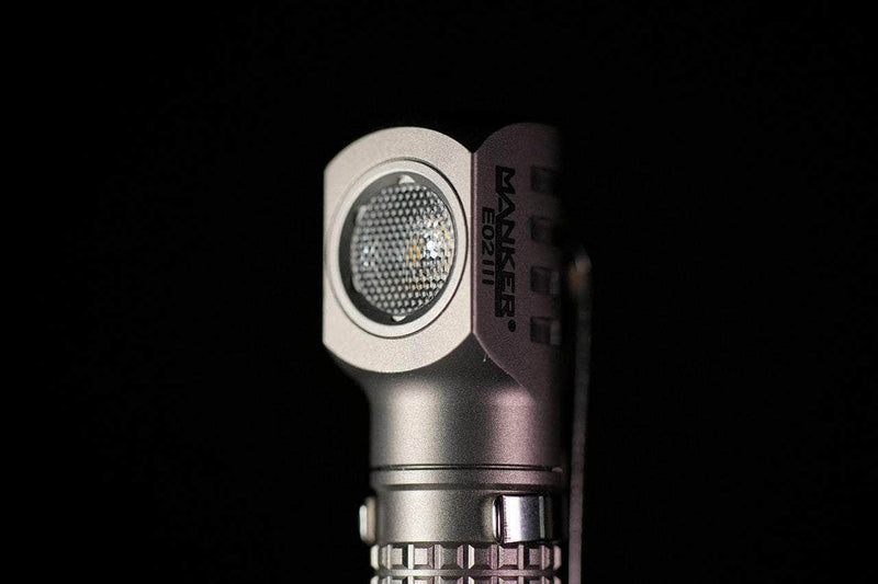 Close-up of a silver Manker E02 III - Titanium flashlight against a black background, ideal for everyday carry.