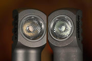 Close-up of two angled Manker E02 III - Titanium flashlights side by side, highlighting their textured lens covers and metallic bodies—each featuring a High CRI Nichia LED for brilliant 560-lumen illumination.