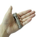 A hand holds the Manker E03H III - Titanium, a compact everyday carry flashlight with a textured grip and angled head, against a white background.
