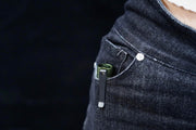 The pocket of a person's jeans has a Manker E05 II in it.