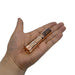 A person's hand holding a Manker E05 II - Copper cigarette lighter.