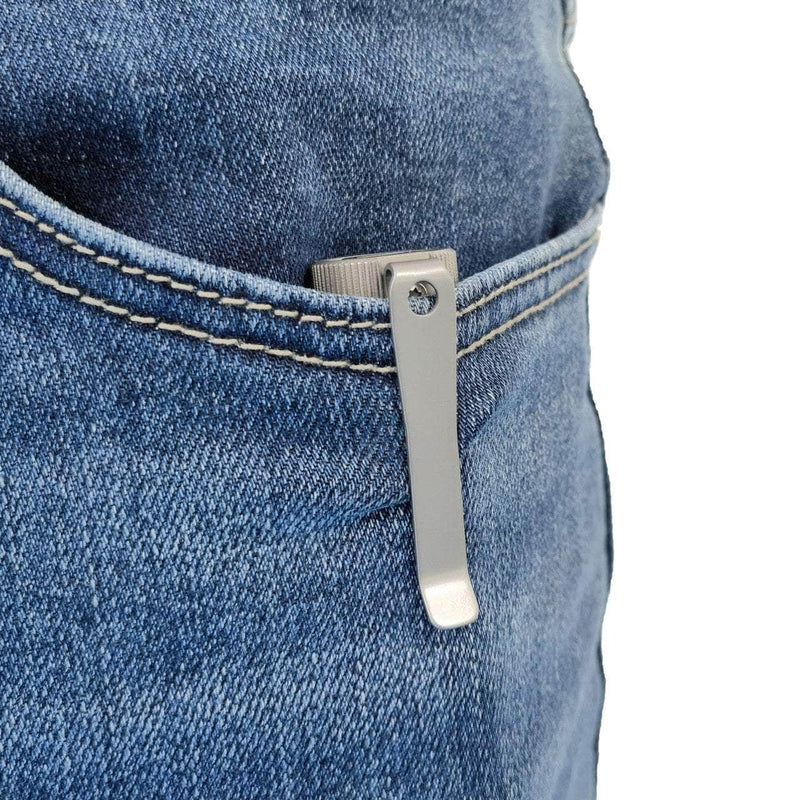 A Manker E05 II Ti - Beadblasted titanium flashlight is clipped to the front pocket of blue denim jeans with its metal clip.