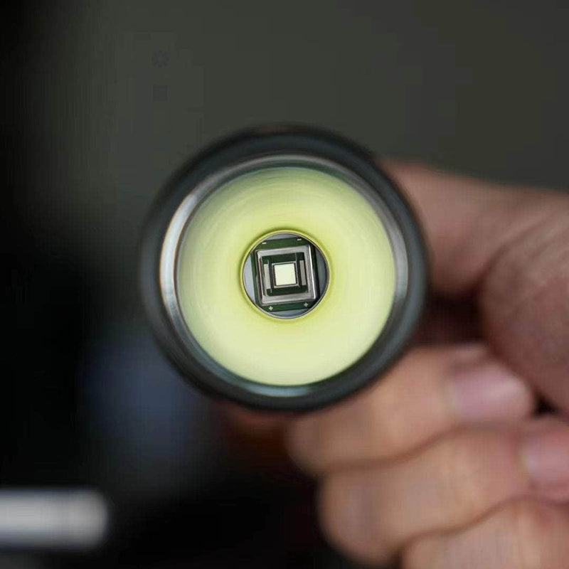 A person holding a Manker MC13 II - SBT90.2 Copper/Black Limited Edition flashlight in their hand.