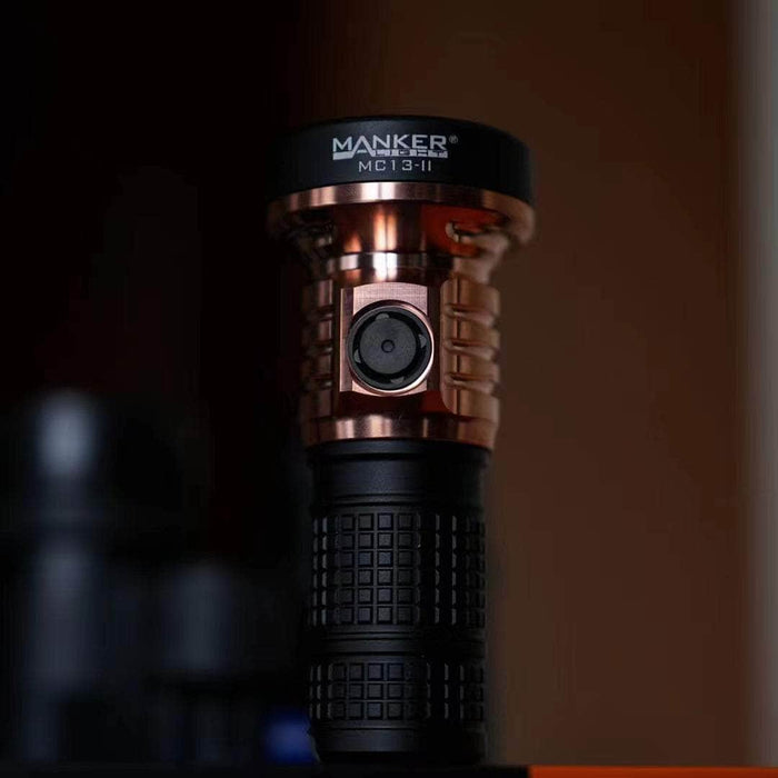 The Manker MC13 II - SBT90.2 Copper/Black Limited Edition is sitting on top of a table.