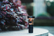 A Manker MC13 II - SBT90.2 Copper/Black Limited Edition flashlight sitting on top of a bench.