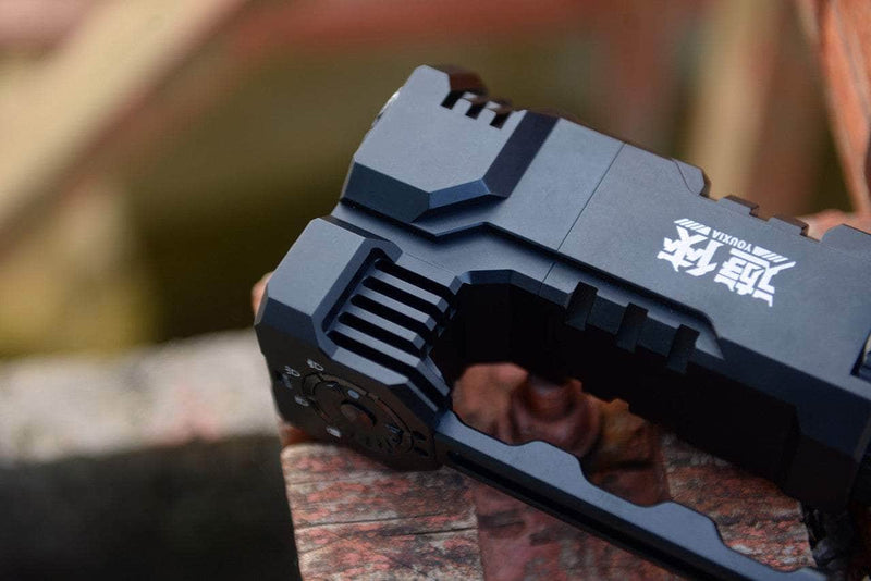 Close-up of the Manker Ranger MK39 II, a black mechanical spotlight with intricate details and markings, resting on red brick surfaces.