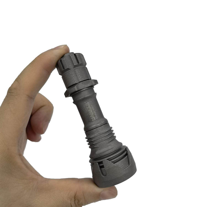 A person holding a Manker Striker Mini Titanium EDC Flashlight in their hand that has high efficiency.