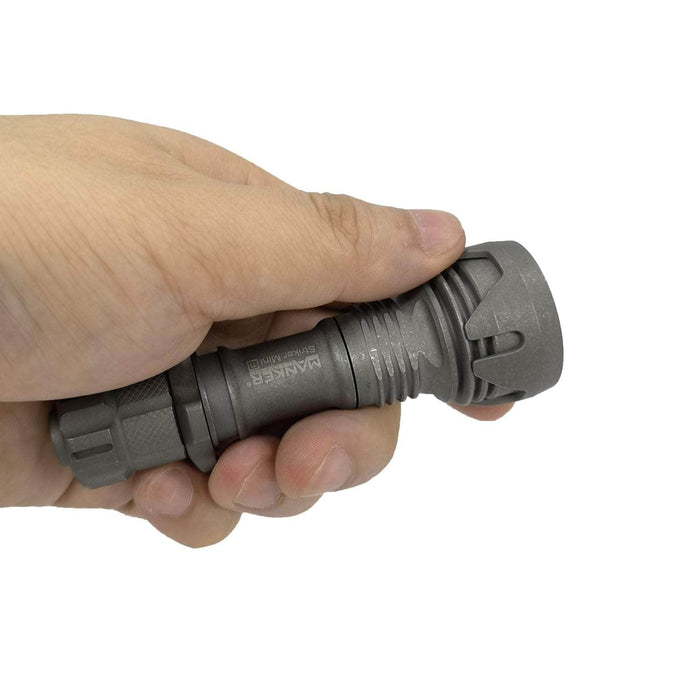 A person holding a Manker Striker Mini Titanium EDC Flashlight in their hand.