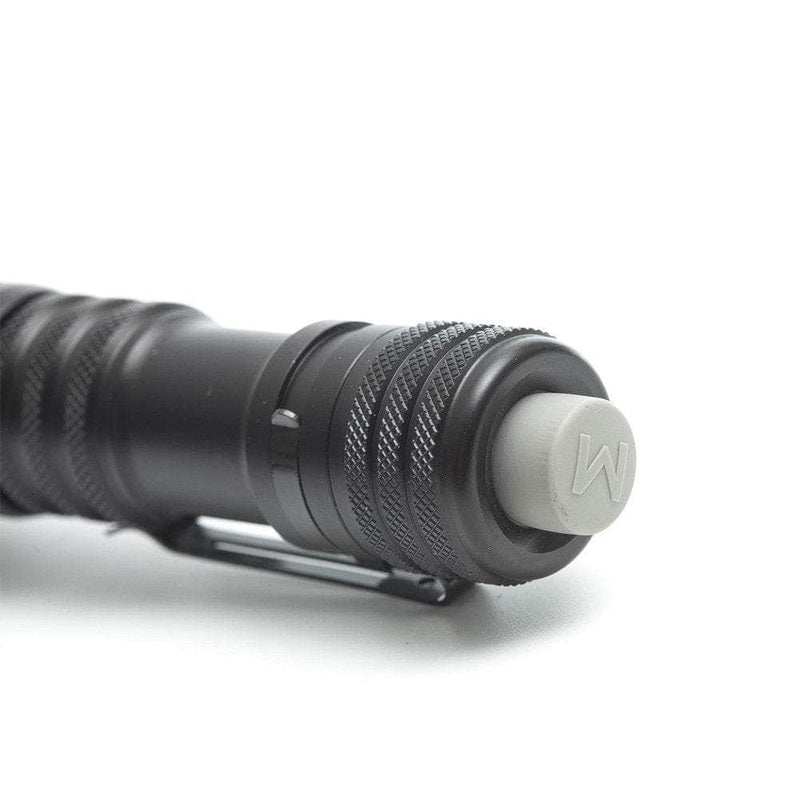Close-up of the end of a black Mankerlight MC12 II Hunter Flashlight with a textured grip and a gray rubber button on the tail cap, marked with the letter "W." It features USB Type-C charging for convenience.