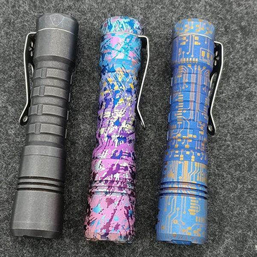 Three Reylight Anodized Ti Pineapples with different designs on them.