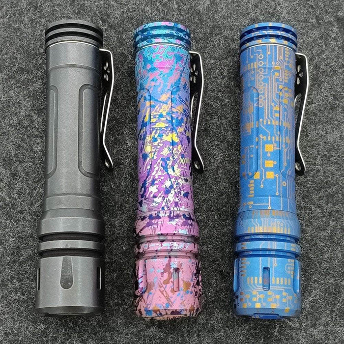 Three Reylight Anodized Ti LAN flashlights with different designs on them.