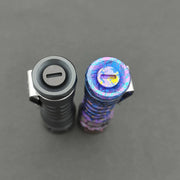 Two flashlights viewed from above on a gray background: one is classic metallic gray titanium, and the other is a ReyLight Anodized Ti LANapple with a multicolored speckled design. Both feature XPL HI 6000K LEDs for superior illumination.