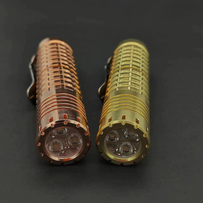 Two ReyLight Dawn - Brass led flashlights on a black surface.