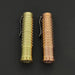 Two different colored ReyLight Dawn - Brass flashlights on a black surface.