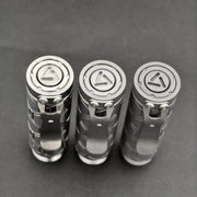 Three ReyLight Dawn Hex - Ti flashlights stand upright on a grey surface, each with a triangular logo on the tail cap, a metal pocket clip, and powered by rechargeable 18350 Li-ion batteries.