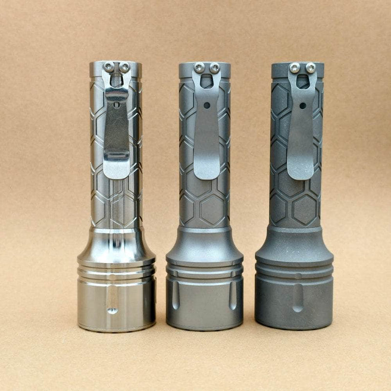 ReyLight Dawn Max 18650 titanium flashlights showing raw, beadblasted, and stonewashed finishes with pocket clips