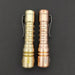 Two Reylight LANapple - Brass flashlights on a black surface.